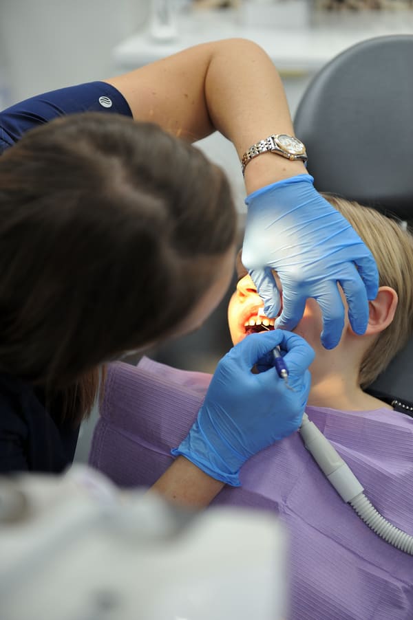 Lekarz Dentystka Joanna sprawdza stan zębów u uśmiechniętego chłopca